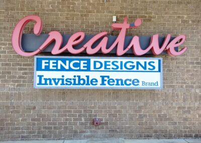 Creative Fence Designs sign on brick wall